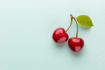 Wall Mural - Cherry berries on a pastel background top view.  Background with a cherry on a sprig, flat lay