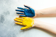 Close-up Of A Person's Hands Painted Yellow And Blue To Symbolise Support Of Ukraine