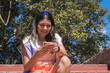 © Fausto - Young woman playing sports outdoors, sharing her day with her cell phone.