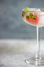 Summer Cocktail With Fresh Raspberries And Strawberries In A Champagne Coupe