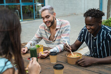 Diverse People Having Fun Eating Takeaway Food Outdoor In The City - Focus On Gay Man Wearing Makeup