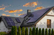 Leinwandbild Motiv Modern house with blue solar panels on the roof. End of the day, sunset. Idyllic atmosphere.