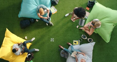 Aufkleber - Diverse group of modern technology students using fun room to boost creativity and innovation. Creative team using a drone while relaxing and working on bean bags in an informal office setup