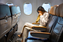 Asian Woman Is Vomitting In The Airplane During The Flight Using Vomit Bag Due To The Motion And Travel Sickness That Cause Dizzy For Aerophobia And Transportation Concept