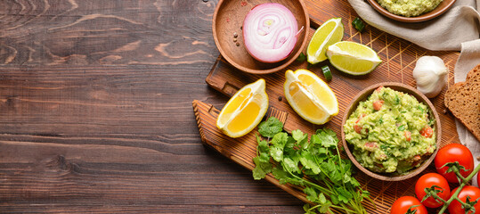 Composition with tasty guacamole and ingredients on wooden background with space for text