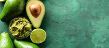 Bowl With Delicious Guacamole, Lime And Ripe Avocados On Green Background With Space For Text