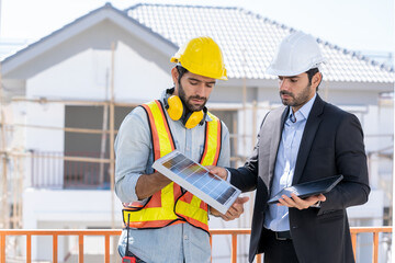 Wall Mural - Engineers with Businessmen discussing and checking solar cell for residential under construction.