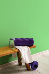 Sticker - Foam roller with towel and bottle of water on bench near green wall