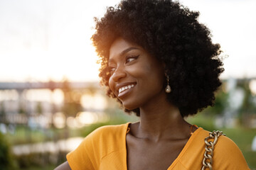 Portrait of a young african american woman smiling standing at the city.