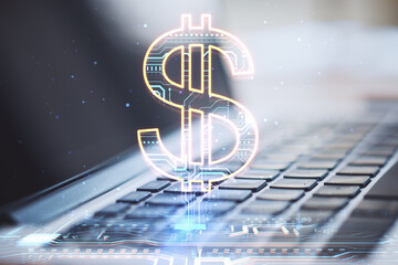Poster - Close up of laptop with creative glowing dollar sign hologram on blurry background. Online banking, technology and currency concept.