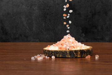 himalayan pink salt and a wooden tray on wooden background