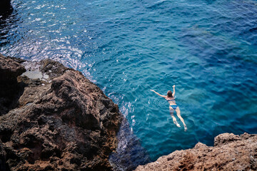 Wall Mural - Vacation. Young woman swimming and bathing at sea rock lagoon.