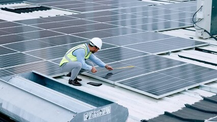 Wall Mural - Solar panels, renewable energy and photovoltaics being installed by an engineer. Engineering technician or electrician doing maintenance on a building roof and using tablet to record measurements