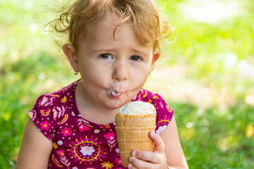 Poster - The child eats ice cream on the street. Selective focus.