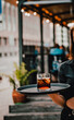 © pavel siamionov - waitress standing in outdoor cafe. girl the waiter holds a tray with a glass of alcoholic cocktail
