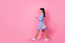 Full Size Profile Photo Of Young Attractive Cute Woman Walking Down Street Holding Phone Chatting Isolated On Pink Color Background