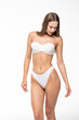 © F8  \ Suport Ukraine - Fit woman in lingerie isolated on white background. Slim attractive female with flat belly in white underwear posing. Copy space for text.