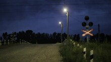 View Of The Railway Crossing With Flashing Traffic Lights At Night