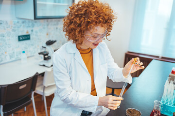 Wall Mural - Modern laboratory interior. Woman working on medical samples in background. Young female scientist standing in her lab. Young Female Scientist Working in The Laboratory