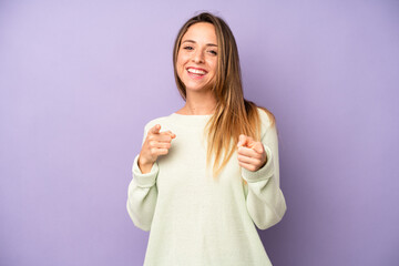 pretty young adult woman smiling with a positive, successful, happy attitude pointing to the camera, making gun sign with hands