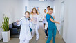 © spoialabrothers - Hospital stuff group of doctors and nurses in front of the camera dancing excited and looking straight to the camera they have large smile