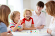 © famveldman - Family playing board game. Kids play.