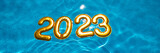 Fototapeta  - banner figures 2023 new year float in the blue pool in splashes of water