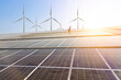 © Kenstocker - Solar cell farm with blue sky and windmill background, renewable energy concept and energy saving.