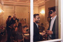 Company Of Friends In Masquerade Masks In Restaurant