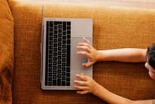 Anonymous Boy Lying On A Sofa Using The Laptop