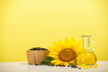 Organic Sunflower Oil In A Small Glass Bottle With Sunflower Seeds And Fresh Flowers On The Table. The Concept Of Organic And Environmentally Friendly Products. Healthy Food And Fats.