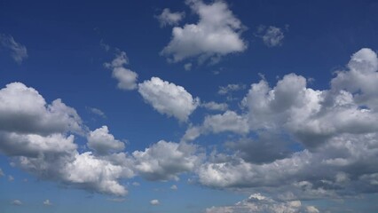 Wall Mural - 4k stock video time lapse of sunny clear blue sky with many white fluffy peaceful clouds flying over