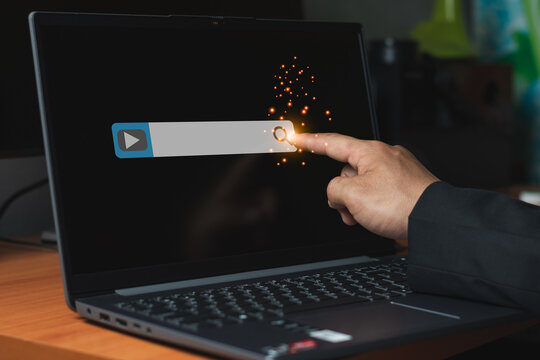 A businessman finger touch video footage bar on the laptop screen for searching information concept, computer graphic light with copy space for text