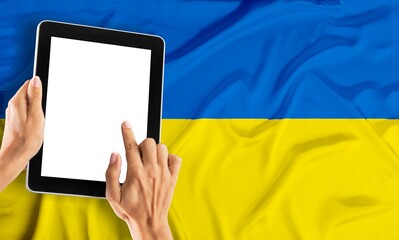 Wall Mural - people sits on a work with a tablet computer for a flag Ukraine