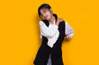 beautiful asian young woman with sore throat neck and shoulder pain isolated on a yellow background
