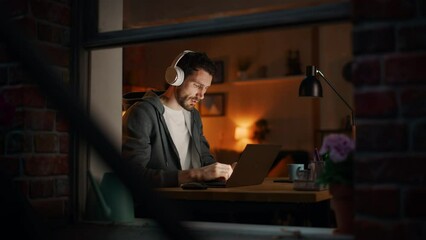Aufkleber - Professional Tireless Software Developer Stretches and Continues Working on Laptop, Writing Code and Working on the Project. Remote Work at Night Time Concept. View From Outdoors into Window.