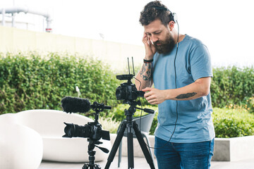 person using a camera Young man making videos with two digital cameras. Independent worker making a video clip with his photography and video equipment