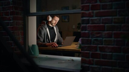 Aufkleber - Software Developer Programming on Laptop Late Night. Male Specialist Browsing Internet, Listening to Podcast, Does Creative Marketing. Remote Work from Home Concept. Medium Close-up Portrait.