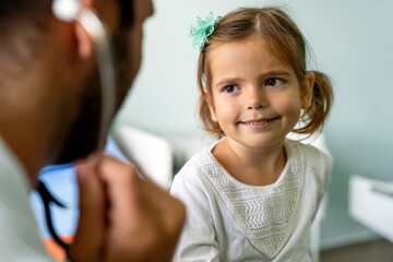 Wall Mural - Male doctor examining a child patient in a hospital