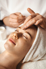 beautician's hands applying anti-aging facial cream, massaging on woman face. skin care. beauty trea