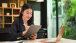 © Prathankarnpap - Professional businesswoman siting front of laptop computer and using digital tablet