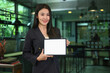 © Prathankarnpap - Confident millennial woman in business suit holding digital tablet, empty screen for your advertise text