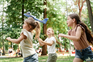 Wall Mural - Group of girls playing together with airplane toy