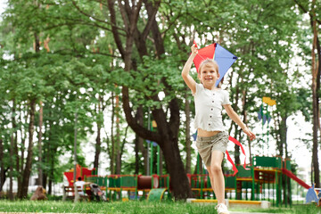 Wall Mural - Blonde girl have fun with kite at playground