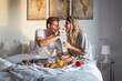 couple with surprise breakfast on bed