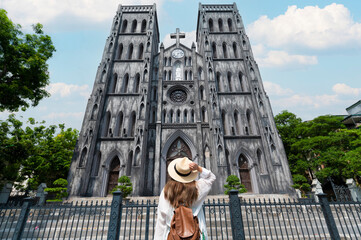 Woman traveller is sightseeing at St Joseph's Cathedral (Nha Tho Lon in Vietnamese) in Hanoi, Vietnam