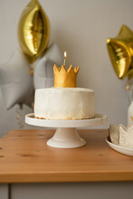 Decorated Table With Cake With Golden Crown And Lightened Candle At A Party