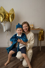Mother Holding Little Boy Dressed Up In A Blue Cap