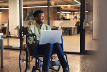 Smiling African American Businessman With Disability Using Laptop In Wheelchair