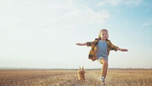 Girl And Dog Running. People In The Park. Little Girl Child Running Across A Mowed Wheat Field With A Pet Dog Happy Smiling. Happy Family Kid Concept. Child Girl Run The Park With Dream A Dog